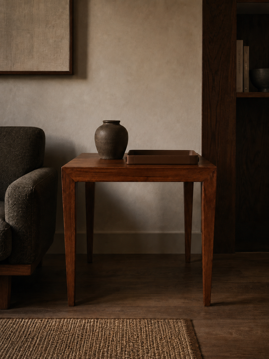 Wooden side table with a vase in a dimly lit room